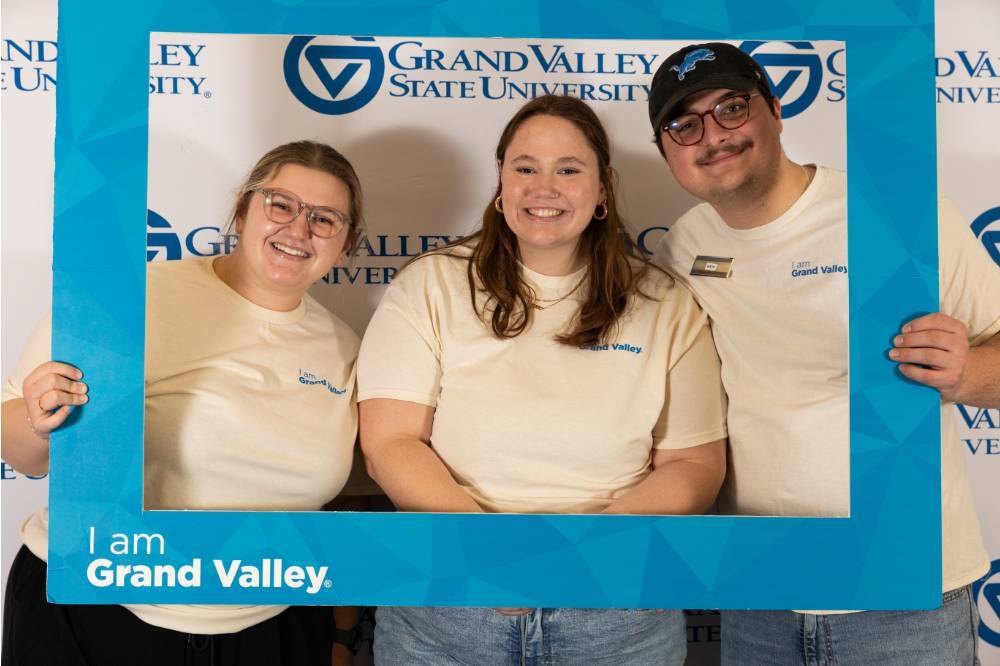 two women and a man at the I am Grand Valley photo booth.